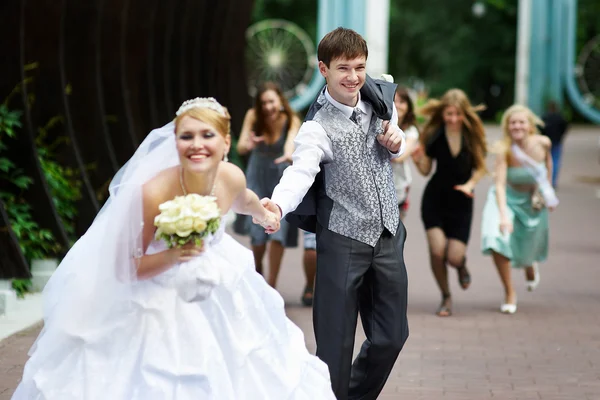 Ευτυχισμένη νύφη φεύγει με τον αρραβωνιαστικό της σχετικά με το γάμο με τα πόδια — Φωτογραφία Αρχείου
