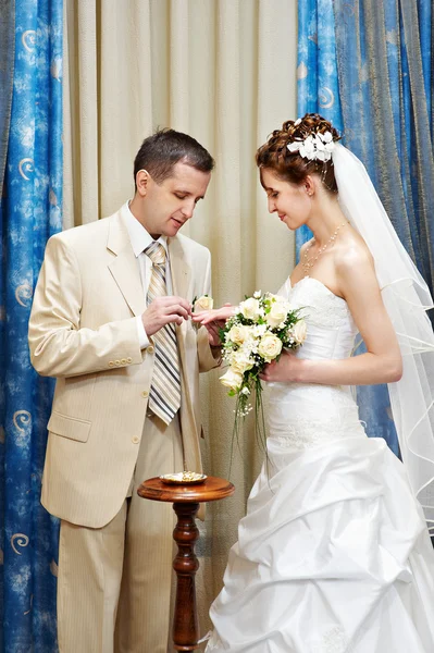 Bruidegom draagt een trouwring een gelukkige bruid — Stockfoto