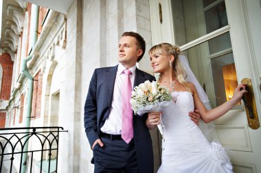 Bride and groom at entrance to palace in Moscow clipart