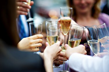 Glasses of champagne in hands of guests at wedding clipart