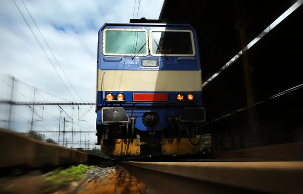 Tåg på spåren vid järnvägsstationen — Stockfoto