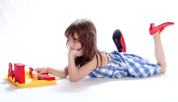 A menina encantadora joga um alojamento de boneca — Fotografia de Stock