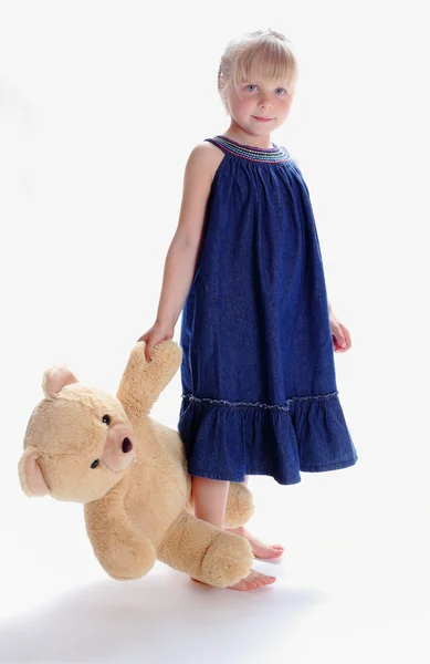 A menina descalça segura por uma pata do ursinho de pelúcia — Fotografia de Stock