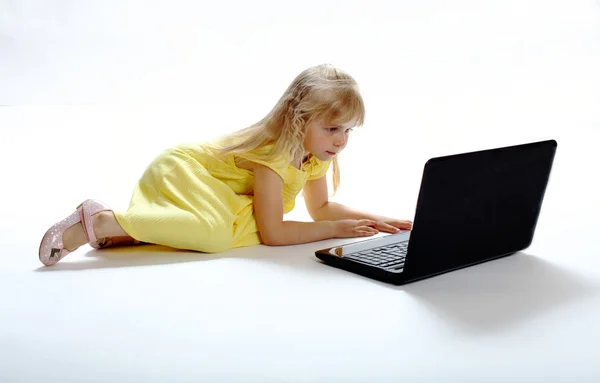 La fille est passionnée par un ordinateur portable — Photo