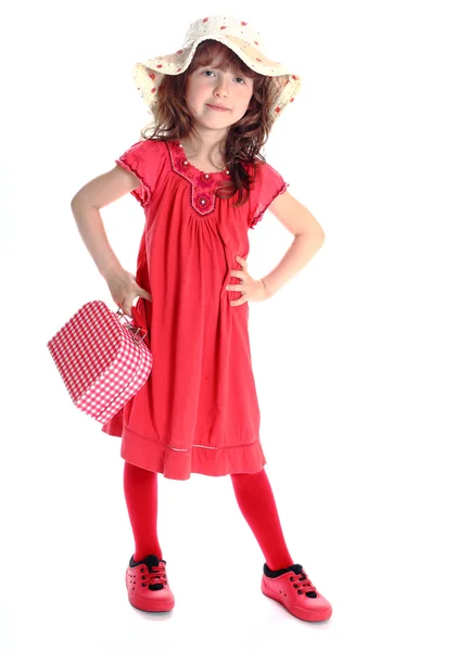 Дівчина в червоній сукні з червоною маленькою валізою — стокове фото