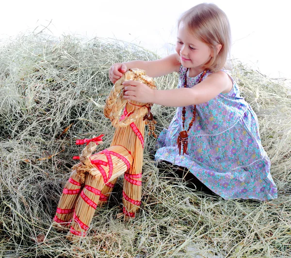 The girl plays on hay a wattled horse — Stock Photo, Image