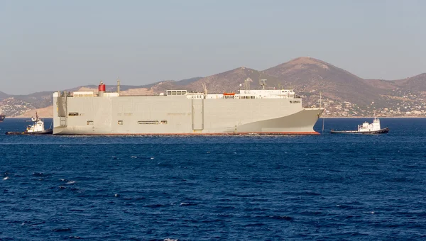 Un gran buque de transporte de vehículos empujado al puerto por dos remolcadores — Foto de Stock