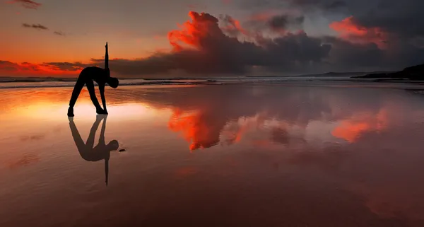 Sylwetka osoby fitness na plaży o zachodzie słońca — Zdjęcie stockowe