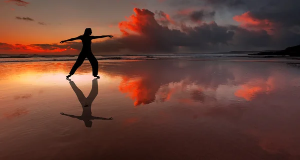 Silhueta de pessoa de fitness em uma praia ao pôr do sol Imagens De Bancos De Imagens Sem Royalties