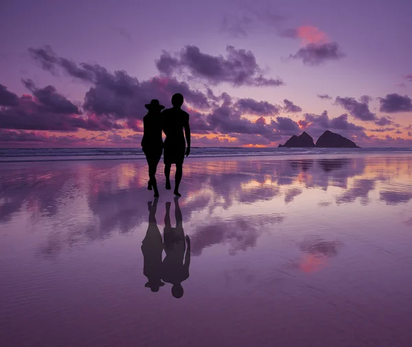 夕暮れ時のビーチでロマンチックな幸せなカップルのシルエット ストック画像