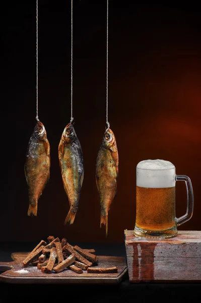 Mug of beer with smoked fish and salty crackers