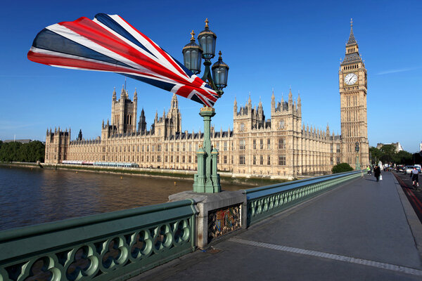 Big Ben with colorful flag of England in London