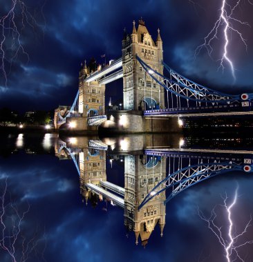 Tower Bridge with lightnings at stormy night in London, UK clipart