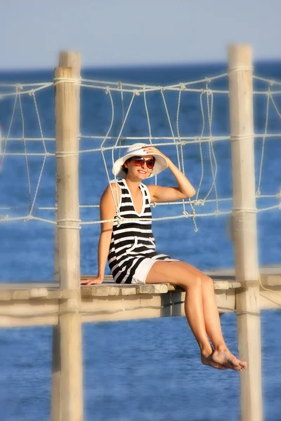 Krásná dívka sedící na dřevěný most — Stock fotografie
