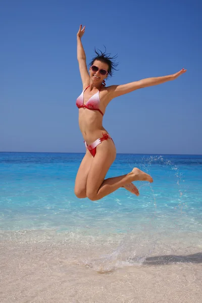 Sexy kobieta skoki na plaży z kolorowe szaliki — Zdjęcie stockowe