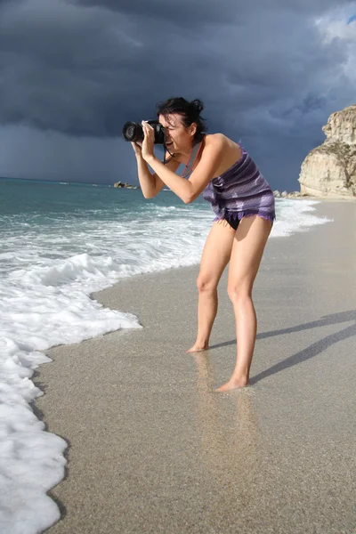 Kvinna fotograf på stranden — Stockfoto