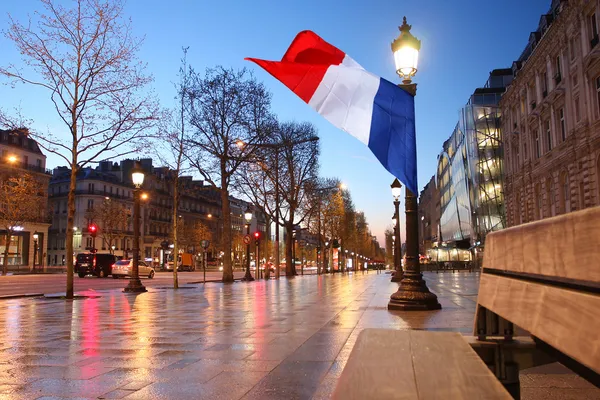 Paris Champs Elysee rua à noite e bandeira da França — Fotografia de Stock
