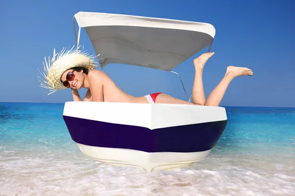 सेक्सी युवा महिला नीले समुद्र के खिलाफ मोटर नाव पर आराम कर रही — स्टॉक फ़ोटो, इमेज