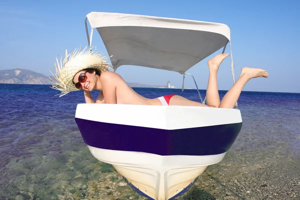 Сексуальная молодая женщина, отдыхающая на моторной лодке против лазурного моря — стоковое фото