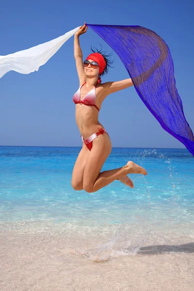 Happy Girl sautant sur la plage avec des écharpes — Photo