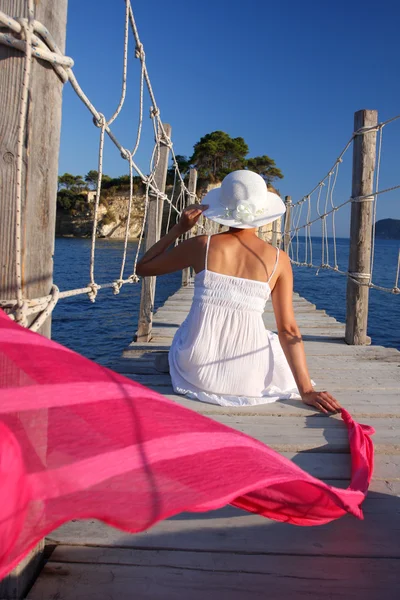 Сексуальная женщина на деревянном мосту над морем — стоковое фото