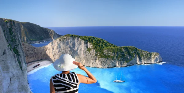 Navagio beach with woman on cliff — Stock Photo, Image
