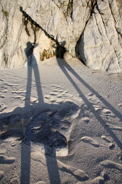 Long shadow of young couple on beach sand — Stock Photo, Image