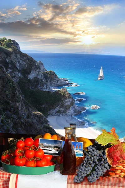 Mesa con vino y fruta contra yate solo en el mar azul —  Fotos de Stock