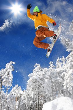 Mavi gökyüzüne atlayan snowboardcu