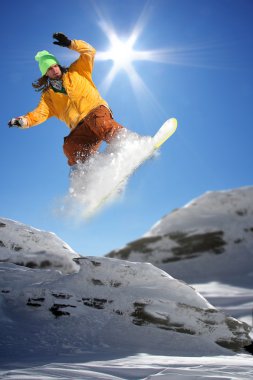 Mavi gökyüzüne atlayan snowboardcu