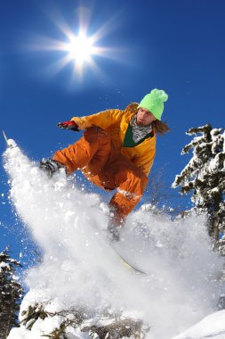 Mavi gökyüzüne atlayan snowboardcu