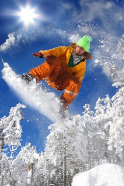 Mavi gökyüzüne atlayan snowboardcu