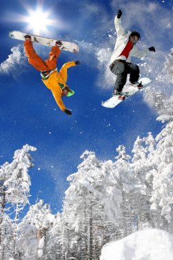 Snowboarder jumping against blue sky clipart