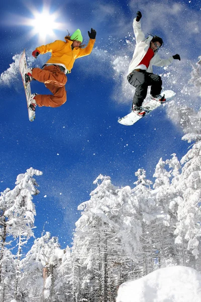 Snowboardisté skoky proti modré obloze — Stock fotografie