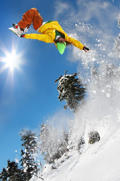 Snowboardåkare hoppar mot blå himmel — Stockfoto