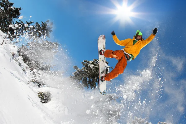 Snowboarder springt gegen blauen Himmel — Stockfoto