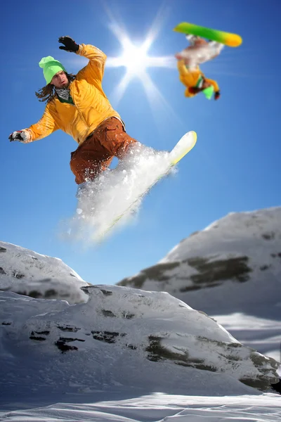 Snowboarders saltando contra o céu azul — Fotografia de Stock