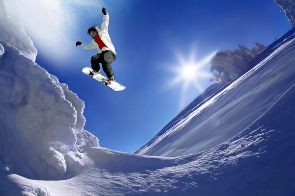 青い空に向かって飛び跳ねるスノーボーダー — ストック写真