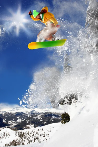 Snowboarder springt gegen blauen Himmel — Stockfoto
