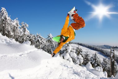 Mavi gökyüzüne atlayan snowboardcu