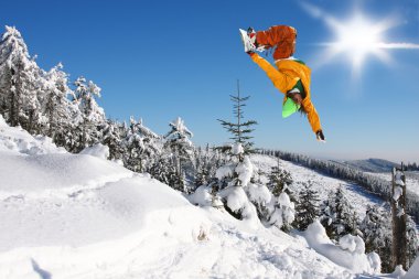 Mavi gökyüzüne atlayan snowboardcu