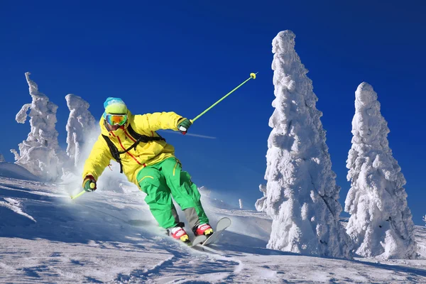 Esquiador esquiando cuesta abajo en las altas montañas — Foto de Stock
