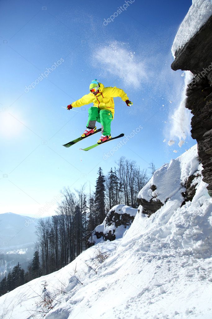 Skier jumping though the air from the cliff