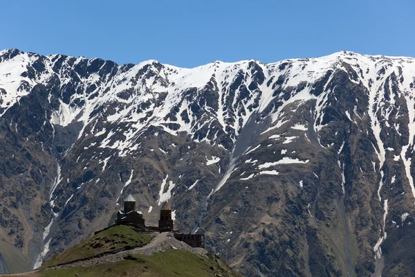 Gergeti trinity church och Kaukasus bergen. stepantsminda. Georgien. — Stockfoto
