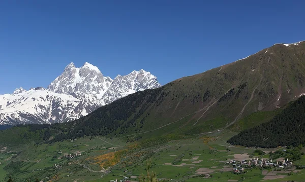 Double pics du Mt. Ushba et Mulakhi Village. Svaneti. Géorgie . — Photo