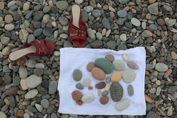 Red shoes and pebbles on a towel. Batumi. Georgia. — Stock Photo, Image