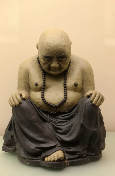 Sitting bowed Buddha. Antique sculpture. Hong kong.