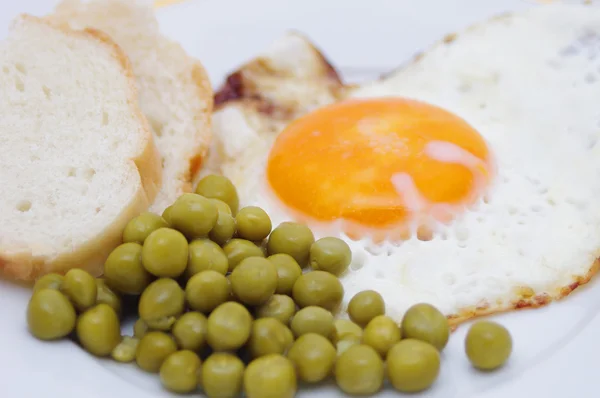 Ovos fritos, pão e ervilha verde — Fotografia de Stock