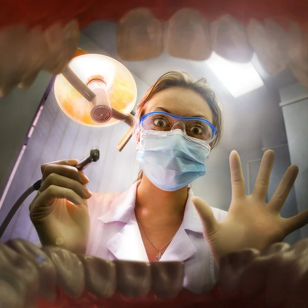 Médica jovem olhando dentro da boca do paciente. Vista de dentro Fotos De Bancos De Imagens