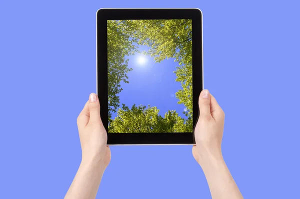 Mão segurando Digital Tablet com céu e árvores — Fotografia de Stock